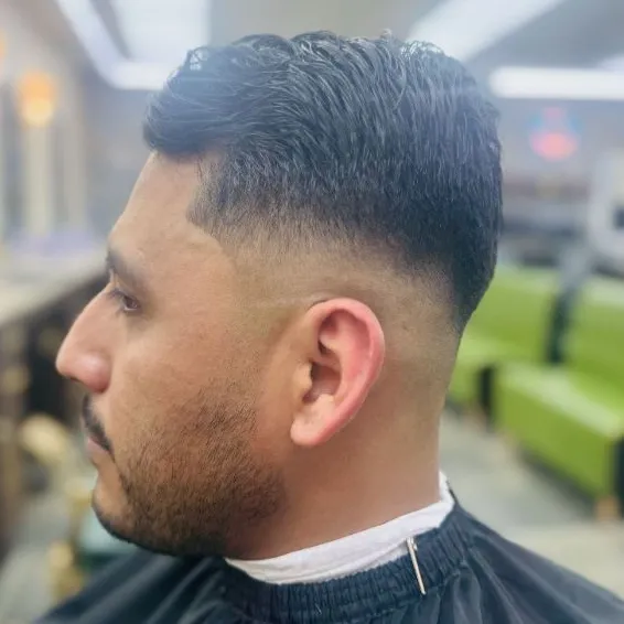 Low taper fade with a short textured top, seen from the side