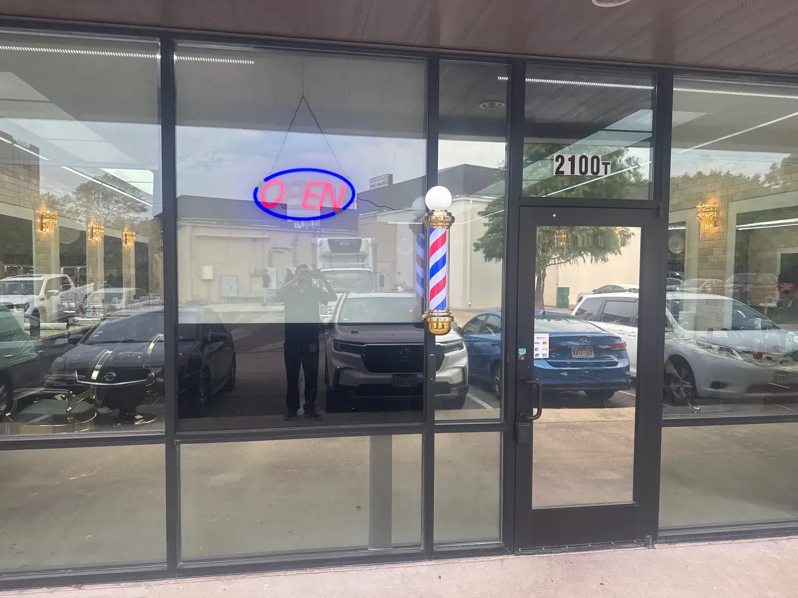 The front door at 2100 Alamo Rd, Ste T, with the barber pole and the open sign