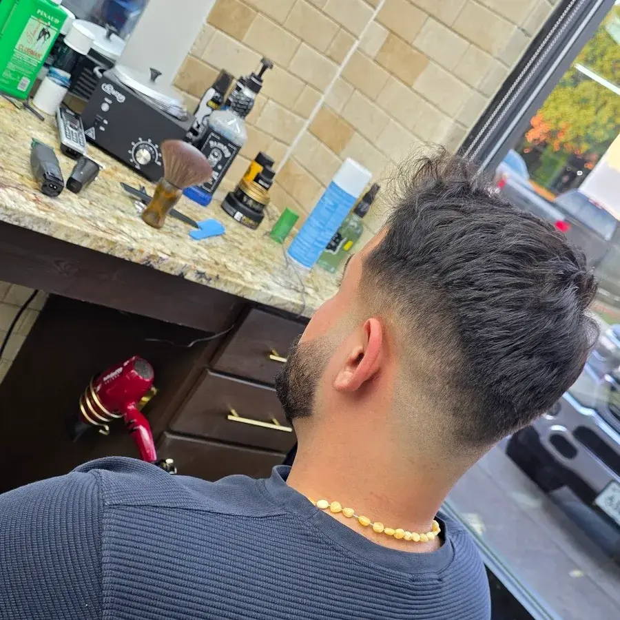 Low fade with a textured top, seen from behind in the chair