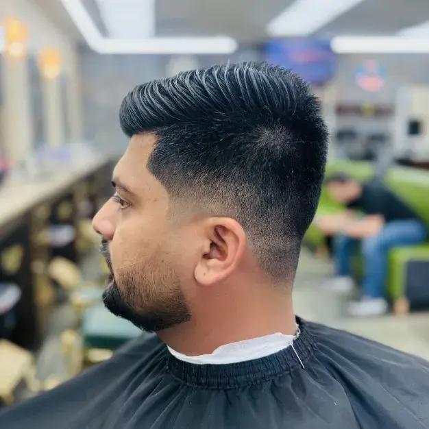 Textured quiff with a mid fade and a sharp temple line